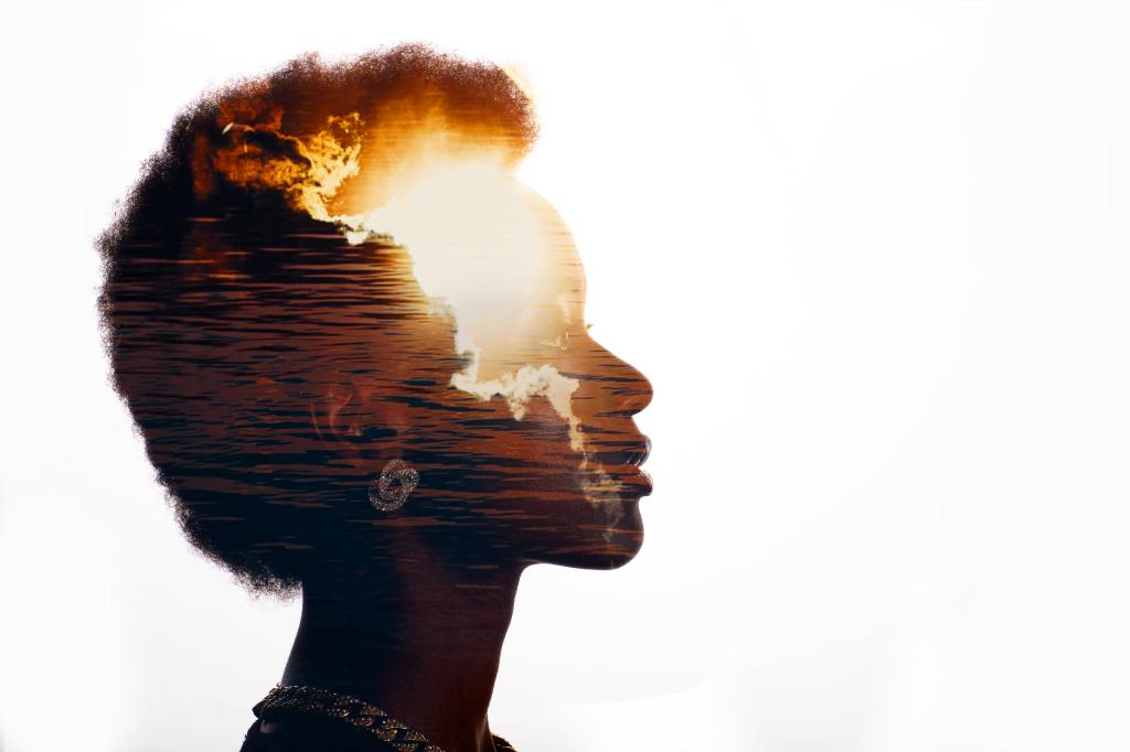 Multiple exposure image with sunrise and sea inside african american woman silhouette. Black Lives Matter mental state and freedom mindset concept.