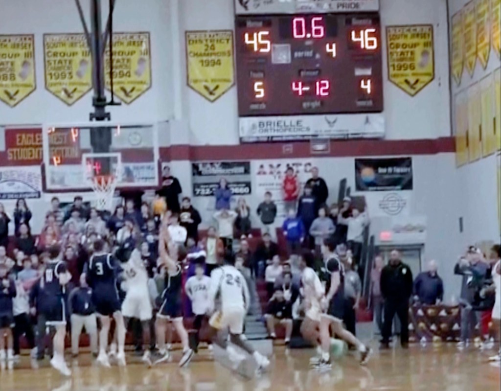 In this image taken from video provided by Joshua Clyburn, Manasquan's Griffin Linstra, center left, shoots as the clock winds down in the NJSIAA Group Tournament semifinal sound group 2 high school basketball game against Camden, Tuesday, March 5, 2024