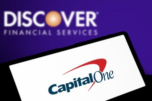 The Capital One website open on a laptop with the Discover logo in the background.