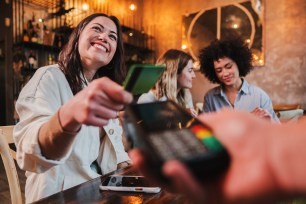 A woman pays for dinner with her credit card.