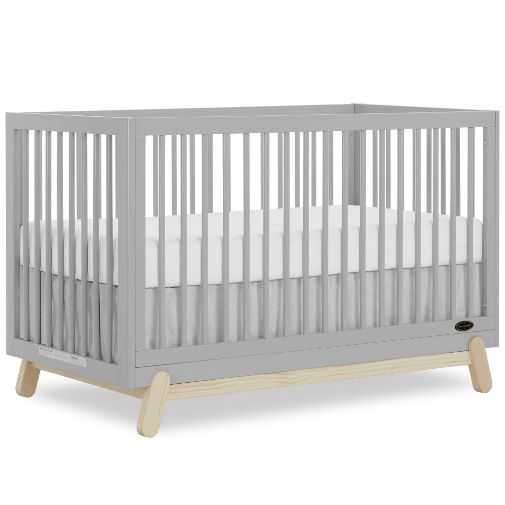 DOM Hygge Crib: a grey crib with white sheets, convertible to daybed, toddler bed, and full-size bed, $200 at Amazon.com.