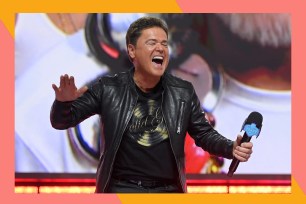 Donny Osmond smiles wide while performing.