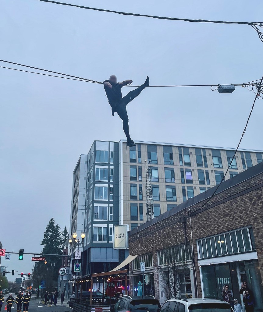 The suspect was dangling from a 20-foot cable before he dropped down on to a Washington state fire truck. 