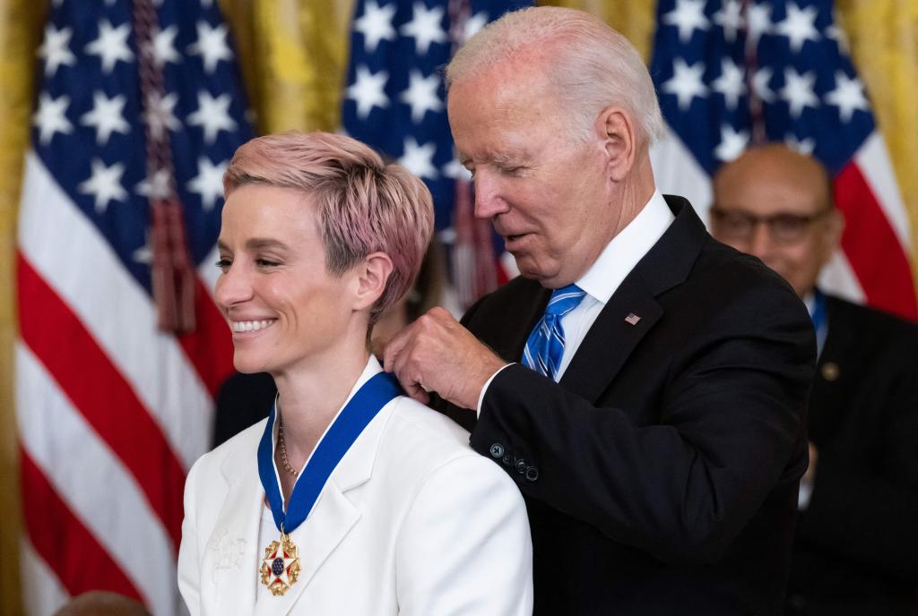 Joe Biden presents US soccer player Megan Rapinoe with the Presidential Medal of Freedom, the nation's highest civilian honor, during a ceremony honoring 17 recipients, in the East Room of the White House in Washington, DC.