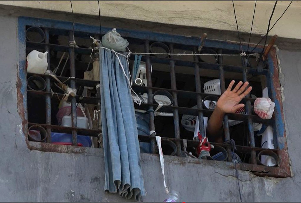 A person waves their hand from a cell inside the main prison of Port-au-Prince, Haiti, on March 3, 2024. 