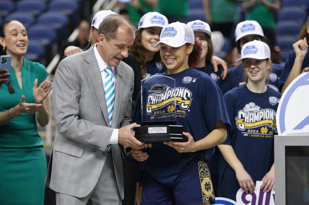 ACC Commissioner Jim Phillips hands the MVP trophy to Notre Dame Fighting Irish guard Hannah Hidalgo (3) in the college basketball game between the Notre Dame Fighting Irish and the NC State Wolfpack.