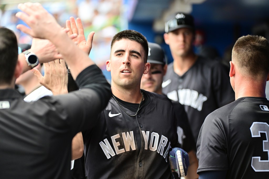 Kevin Smith #74 of the New York Yankees celebrates with teammates after scoring in the third inning against the Toronto Blue Jays during a 2024 Grapefruit League Spring Training game.