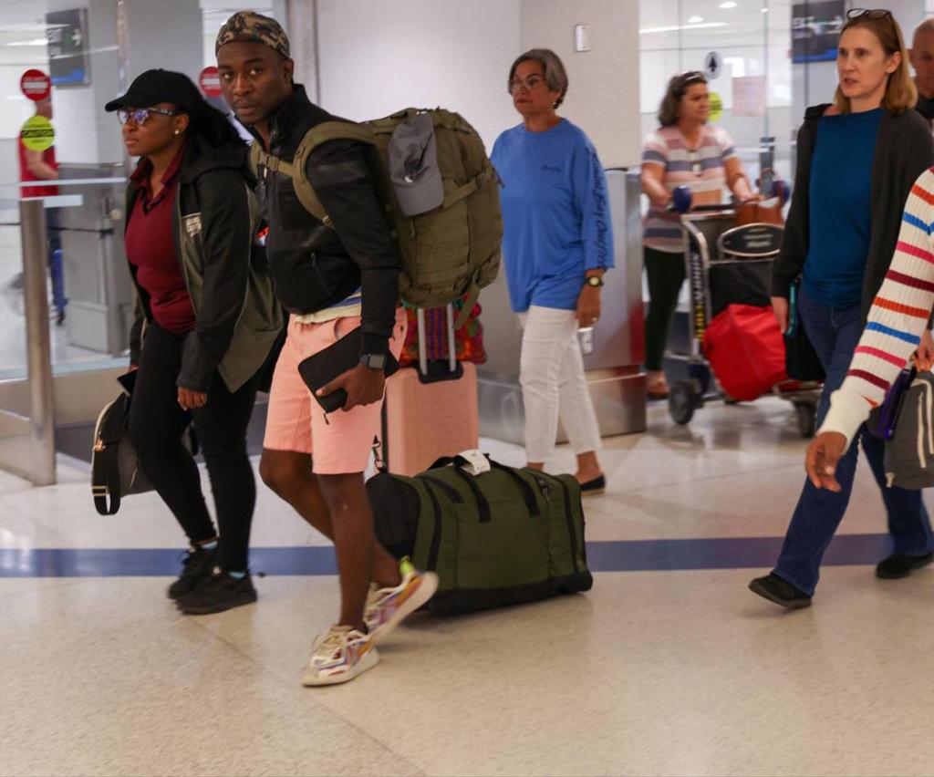 Passengers walk through the Arrivals area after arriving on the first evacuation flight out of Cap-Haitien, Haiti, at Miami International Airport on March 17, 2024. 