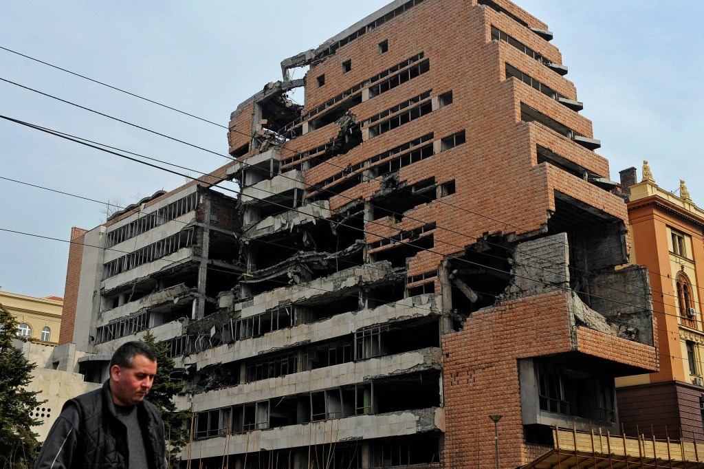 A man walks past the building of former federal military headquarters in Belgrade on March 24, 2010, destroyed during the 1999 NATO air campaign against Yugoslavia. 