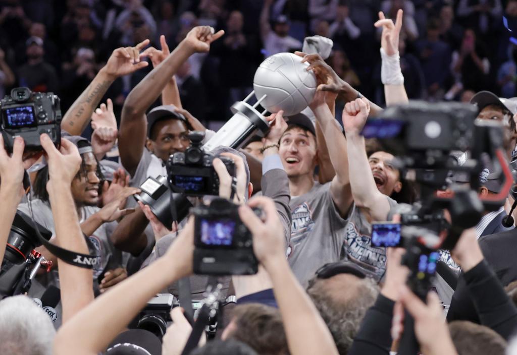 UConn players celebrate after their 73-57 Big East Tournament-clinching win over Marquette.