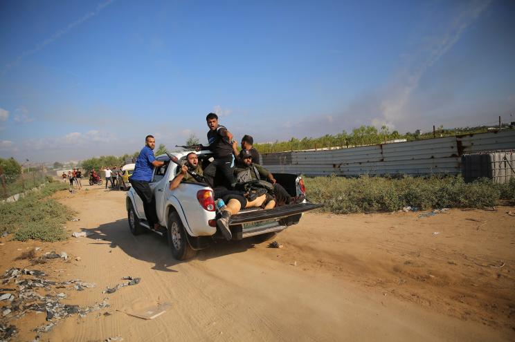 Hamas terrorists in a pickup truck transport the body of Shani Louk, a German-Israeli dual citizen, back to the Gaza Strip.