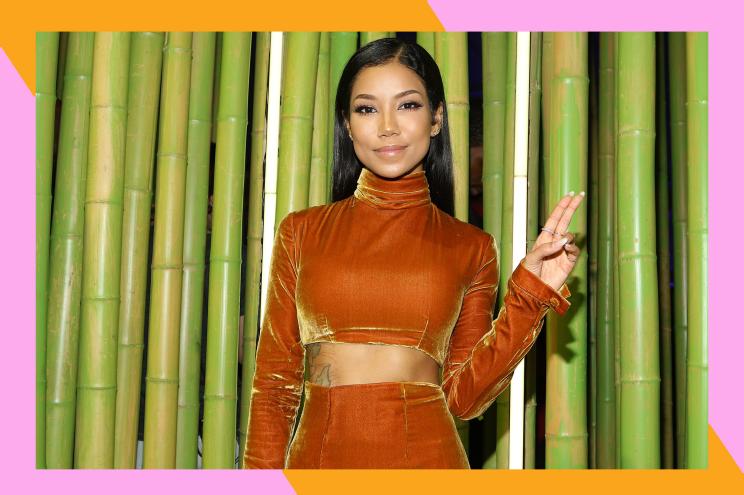 Jhené Aiko flashes a peace sign from the red carpet.