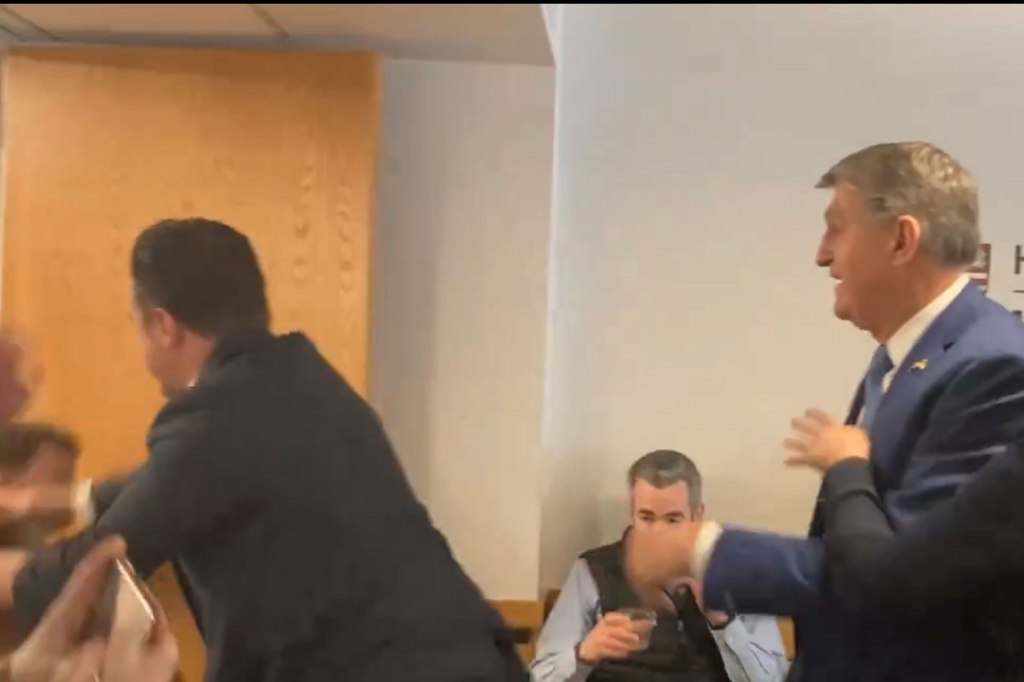 The man, identified as one of Manchin’s aides by the Harvard Crimson, then violently shoved the protester out of the room. 