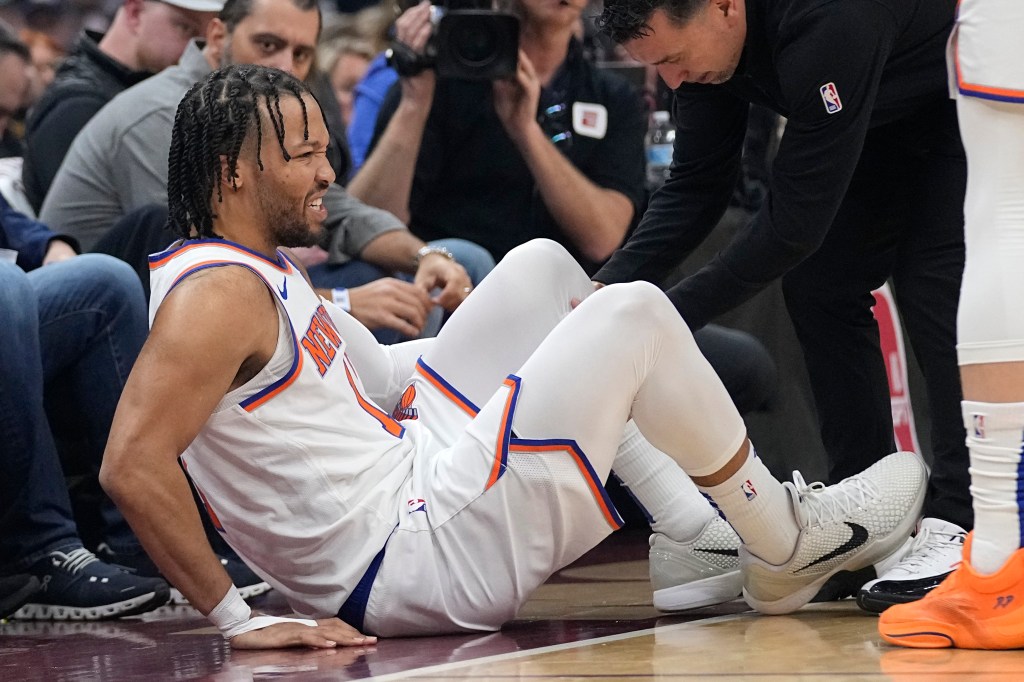 New York Knicks guard Jalen Brunson (11) is tended to after an injury in the first half of an NBA basketball game against the Cleveland Cavaliers, Sunday, March 3, 2024, in Cleveland.