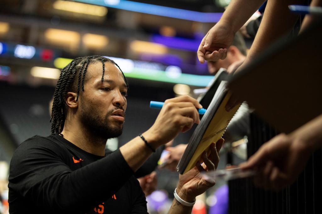 New York Knicks guard Jalen Brunson signs autographs following pregame warmups before an NBA basketball game against the Sacramento Kings in Sacramento, Calif., Saturday, March 16, 2024.