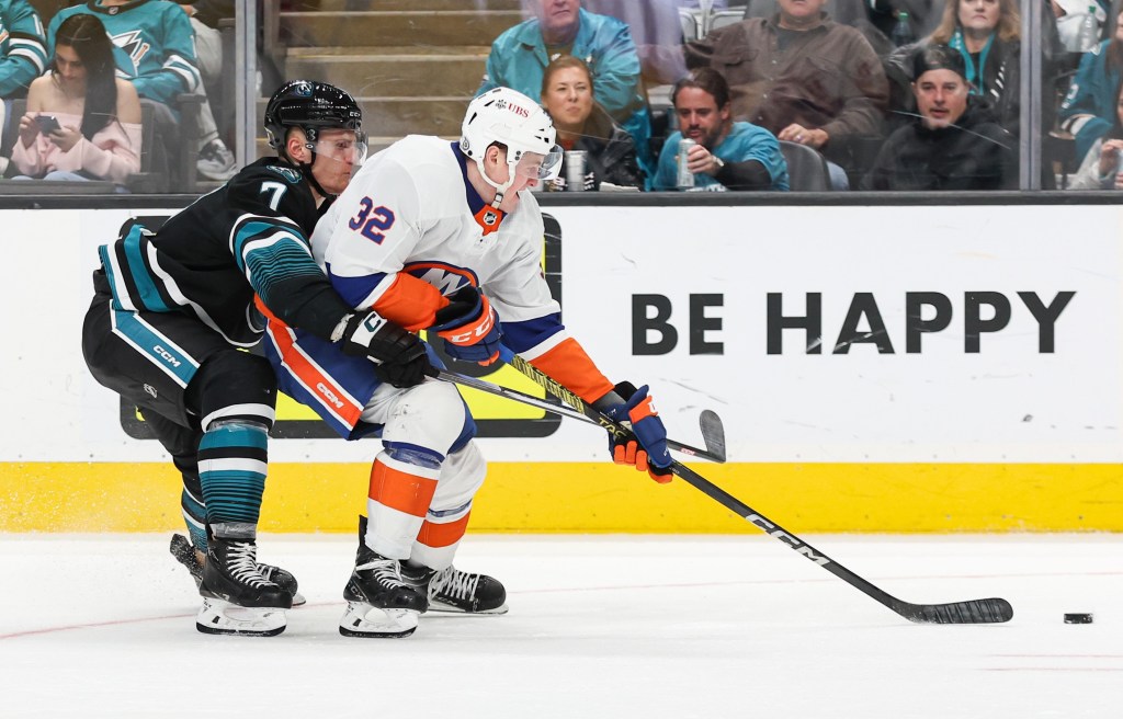 Kyle MacLean looks to keep the puck away from the Sharks' Nico Sturm during the Islanders' win.