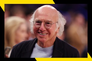 Larry David smiles while attending a basketball game.
