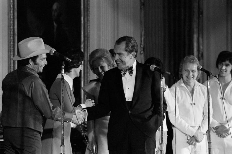 Country music singer Merle Haggard, left, is greeted by President Richard Nixon and first lady Pat Nixon at the White House, where Haggard entertained the president and his wife on her birthday celebration, March 19, 1973.