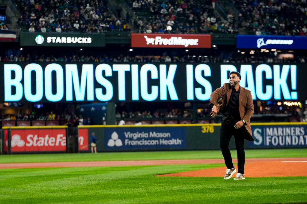 Nelson Cruz throws out the ceremonial first pitch before the team's opening-day baseball game against the Boston Red Sox, on March 28, 2024, in Seattle. 