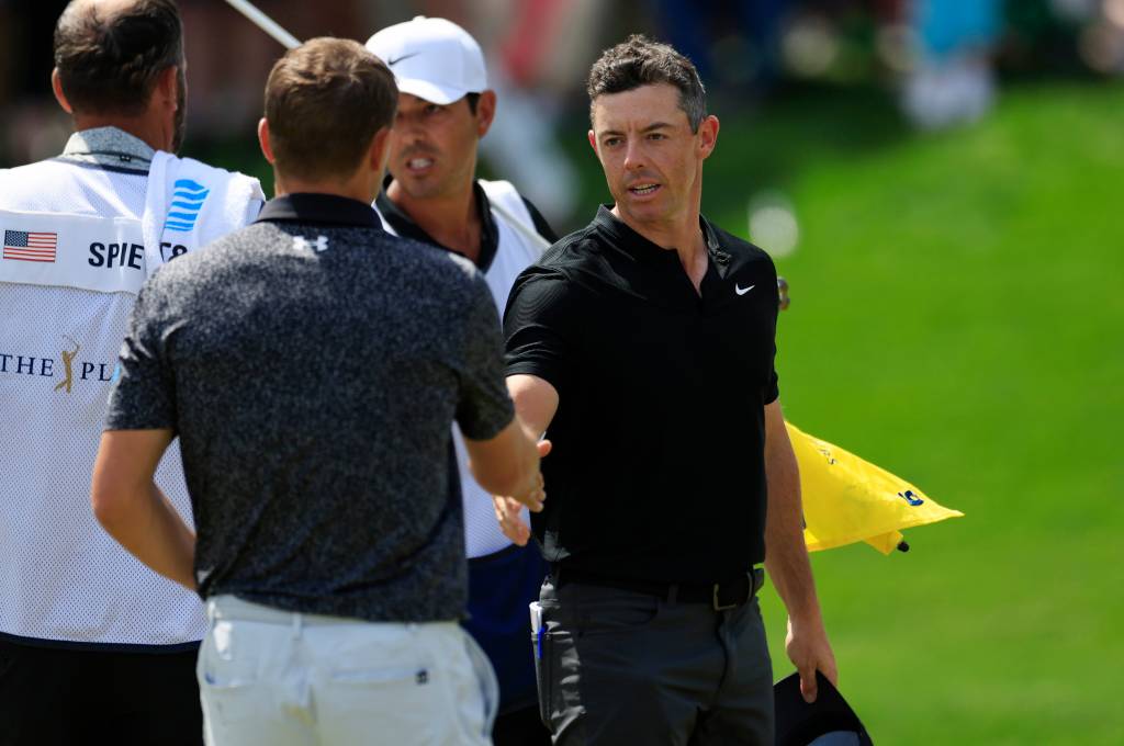 Rory McIlroy shakes hands with Jordan Spieth after both players completed their first rounds.