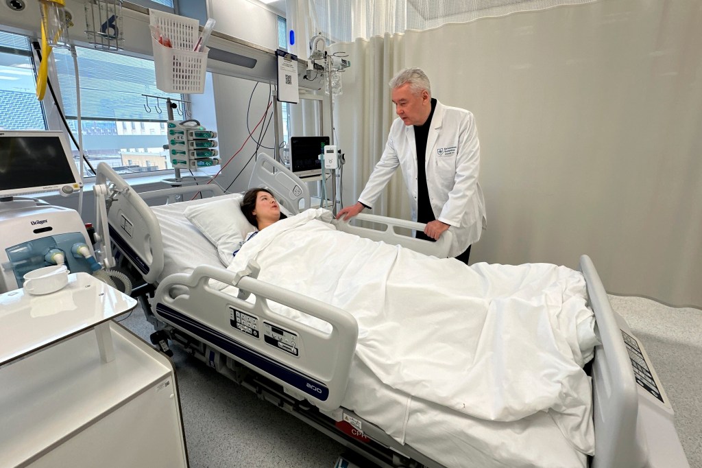 Moscow Mayor Sergei Sobyanin speaks to a wounded person after an attack at the Crocus City Hall, in the hospital in Moscow, Russia, Saturday, March 23, 2024. 