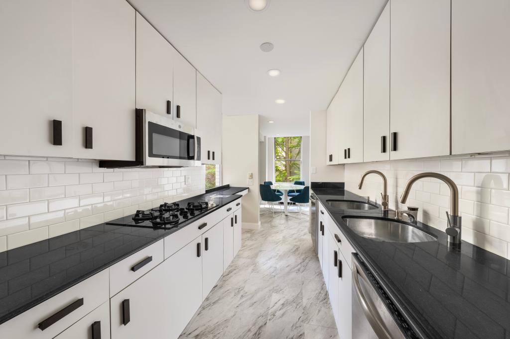 A luxury kitchen with white cabinets and black countertops.