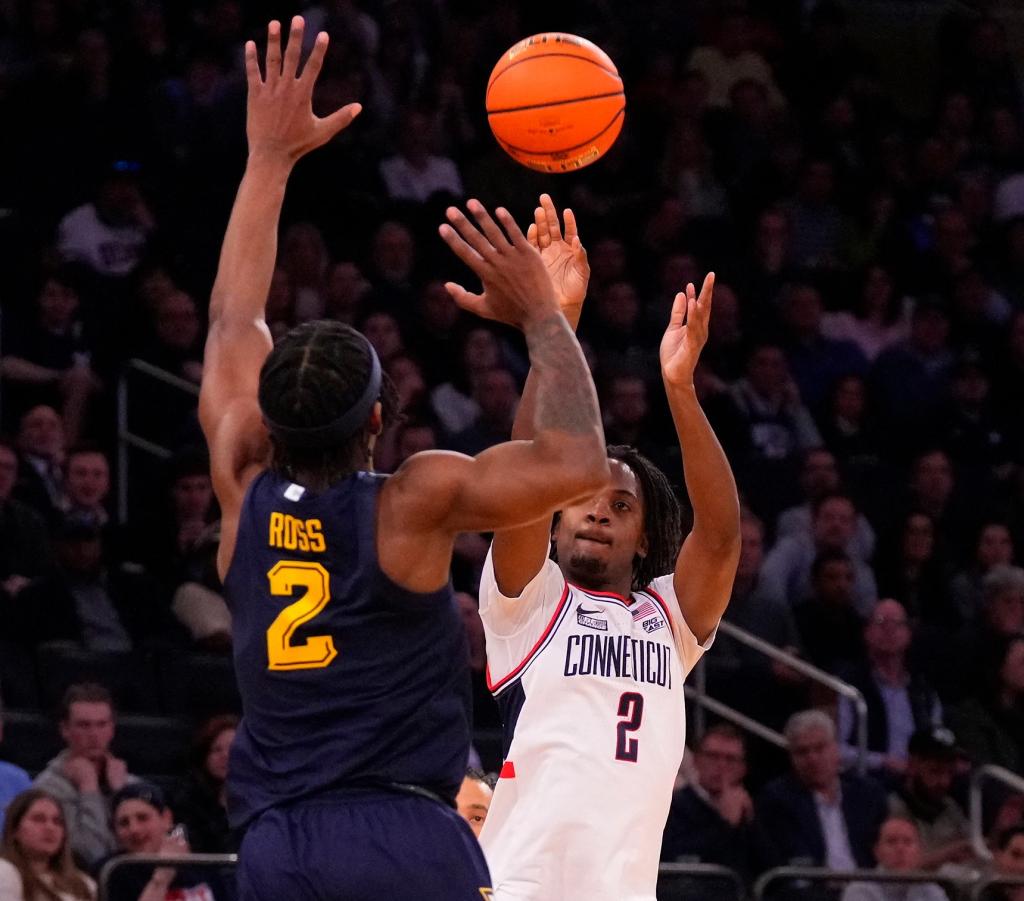 Tristen Newton, who had 13 points and 10 rebounds, shots over Chase Ross during UConn's win.