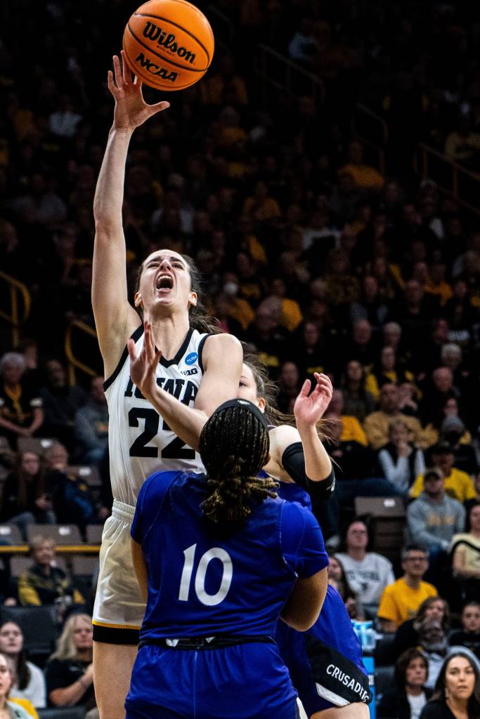 Iowa guard Caitlin Clark (22) attempts a basket against Holy Cross forward Janelle Allen (10) during an NCAA tournament first-round game at Carver-Hawkeye Arena