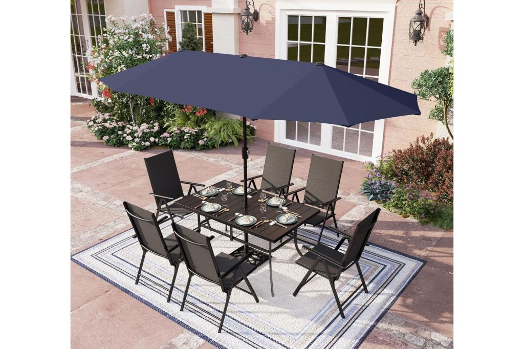 An outdoor dining table with six chairs and an umbrella.