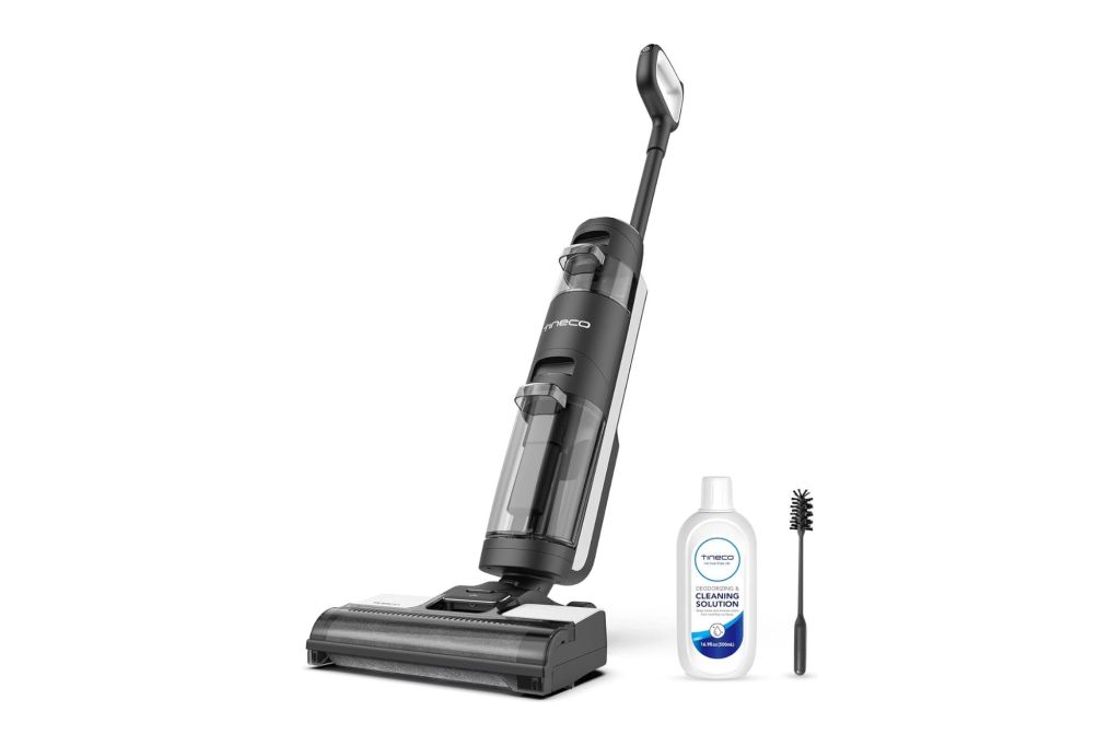 A vacuum with cleaning solution and a brush.