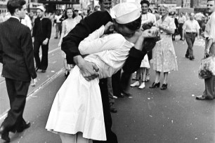 As pedestrians watch, an American sailor passionately kisses a white-uniformed nurse in Times Square to celebrate the long awaited-victory over Japan. August 14, 1945.