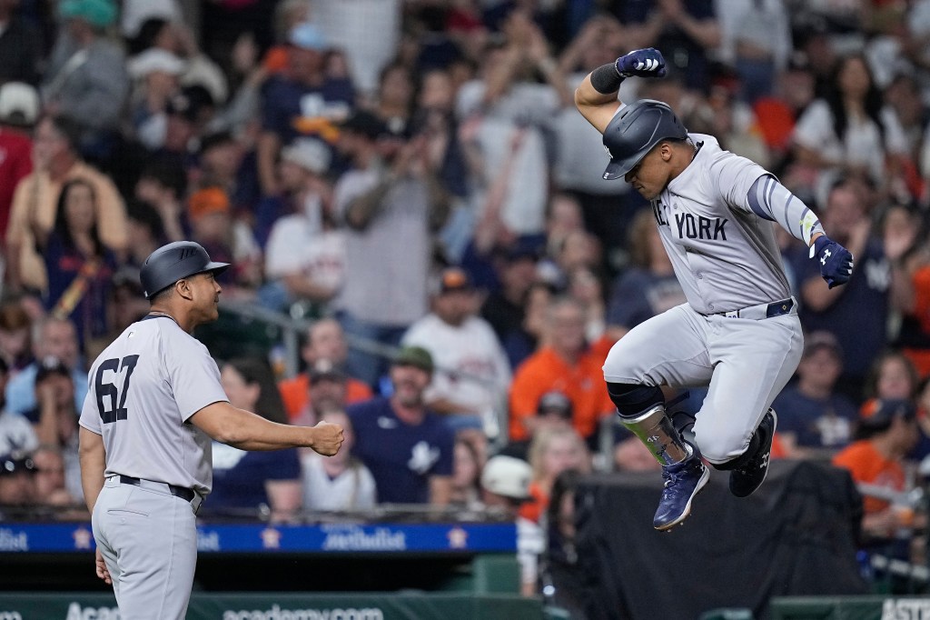 New York Yankees' Juan Soto, right, celebrates with third base coach Luis Rojas after hitting a solo home run against the Houston Astros during the seventh inning of a baseball game Saturday, March 30, 2024, in Houston.