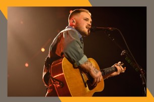 Zach Bryan sings while playing guitar.