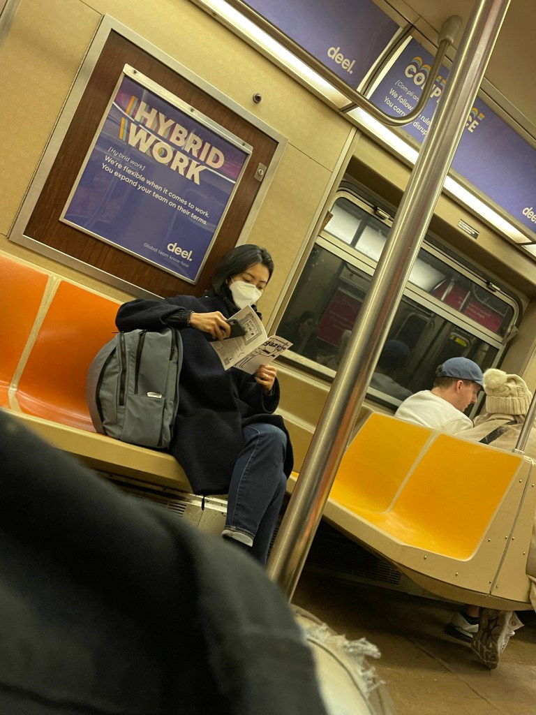 woman reading public transport magazine on a subway car