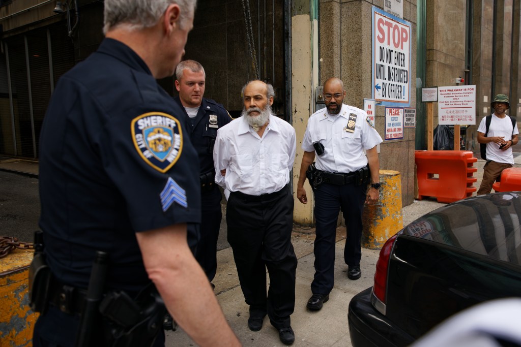 Jose Alba being escorted out of jail by police officers and sheriff's deputies.