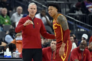 Head coach Andy Enfield of the USC Trojans speaks with Boogie Ellis #5 of the USC Trojans in the second half of a first round game against the Washington Huskies.