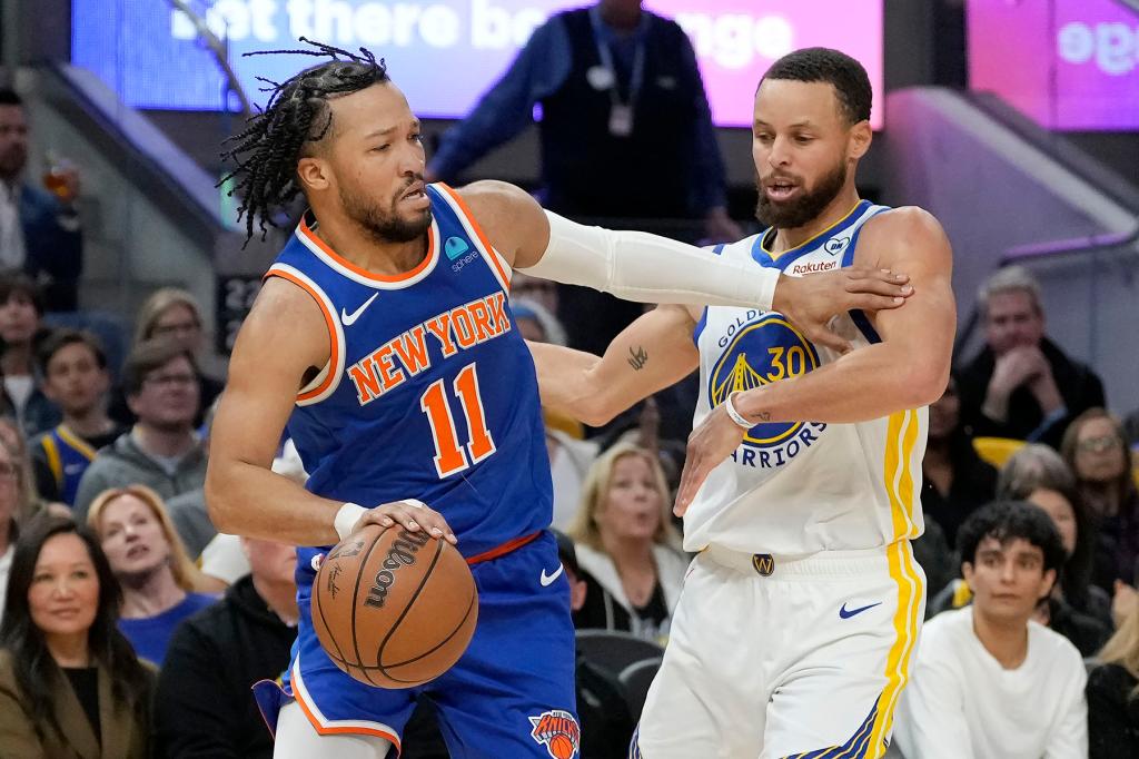 New York Knicks guard Jalen Brunson (11) drives to the basket against Golden State Warriors guard Stephen Curry during the first half of an NBA basketball game in San Francisco, Monday, March 18, 2024. 