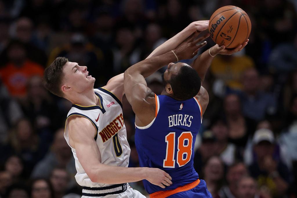 Christian Braun #0 of the Denver Nuggets stops Alec Burks #18 of the New York Knicks during the fourth quarter at Ball Arena on March 21, 2024 in Denver, Colorado.