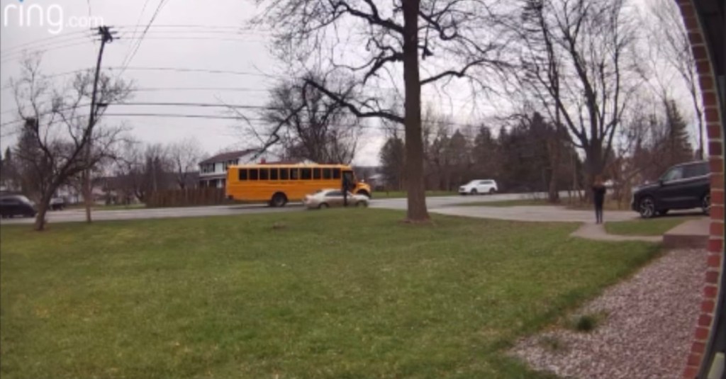 The car passed directly in front of where the student would exit, but fortunately, the bus driver was able to pull her back inside.