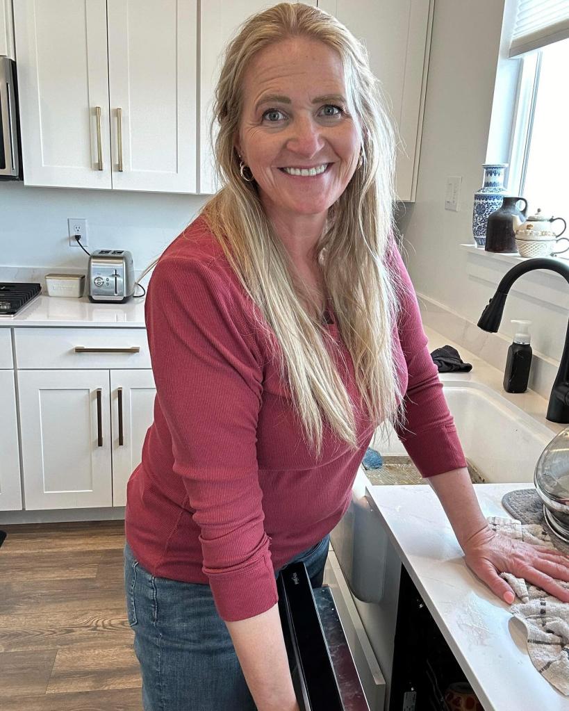 Christine Brown smiling standing at a sink. 