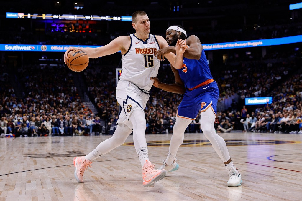 Nikola Jokic (15) controls the ball as New York Knicks forward Precious Achiuwa (5) guards in the first quarter at Ball Arena.