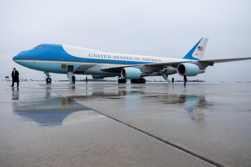 Air Force One, seen from a distance on a wet runway.
