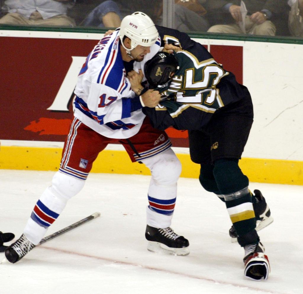 Rangers forward Chris Simon (17) and Dallas Stars defenseman John Erskine (55) fight during the first period of their game in Dallas, Friday, Sept. 19, 2003