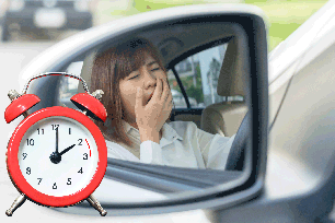 A woman yawning in a car with the filename \"daylight-savings\".