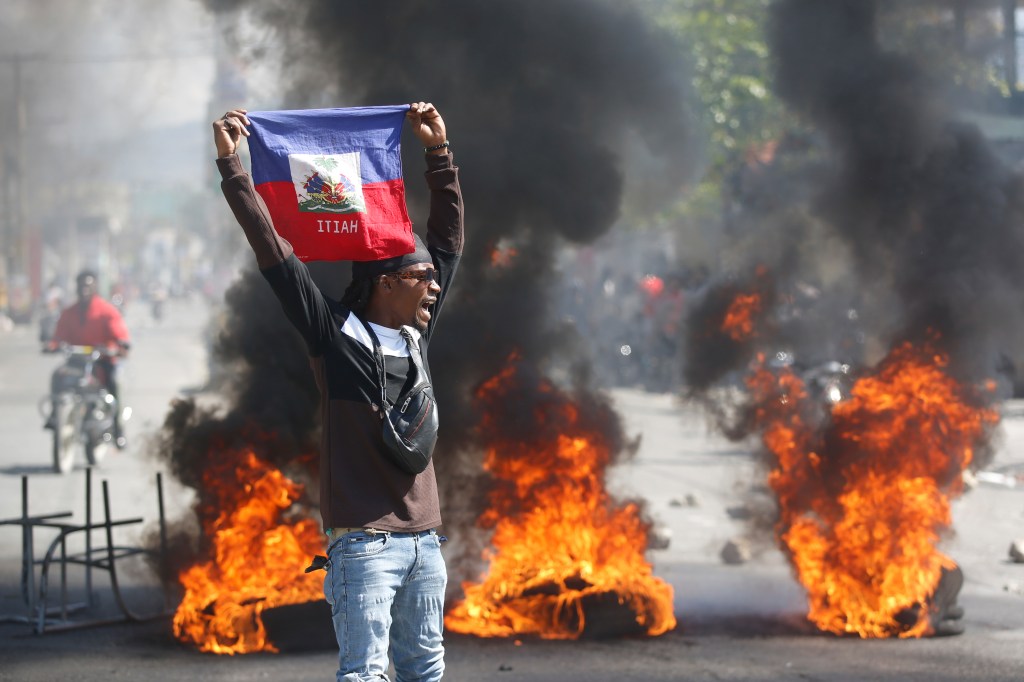 A demonstrator holding up a Haitian flag during protests in Port-au-Prince, Haiti on March 1, 2024.