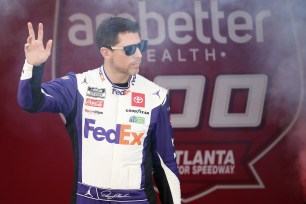 Denny Hamlin, driver of the #11 FedEx Toyota, waves to fans as he walks onstage during driver intros prior to the NASCAR Cup Series Ambetter Health 400.