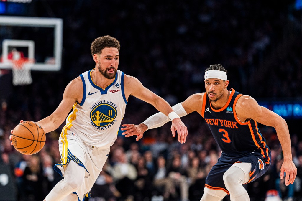 Klay Thompson of Golden State Warriors drives to the basket against Josh Hart of New York Knicks during NBA game.