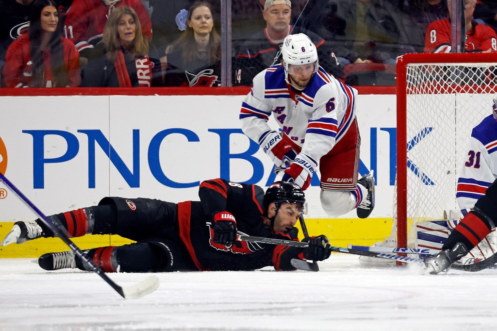 Hurricanes' Jordan Martinook (48) falls to the ice in front of New York Rangers' Zac Jones