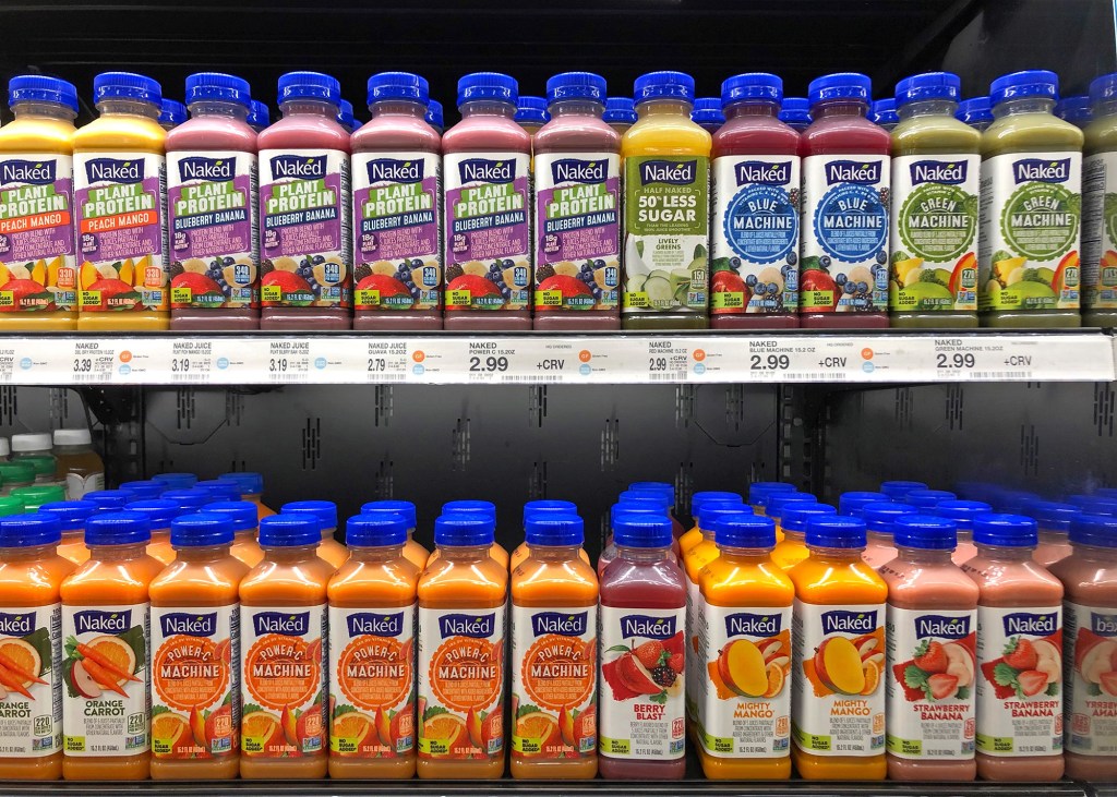 Bottles of Naked Juice on grocery store shelves in various flavors