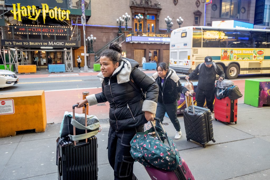 A group of migrants walk down 42nd Street. Migrants around Times Square